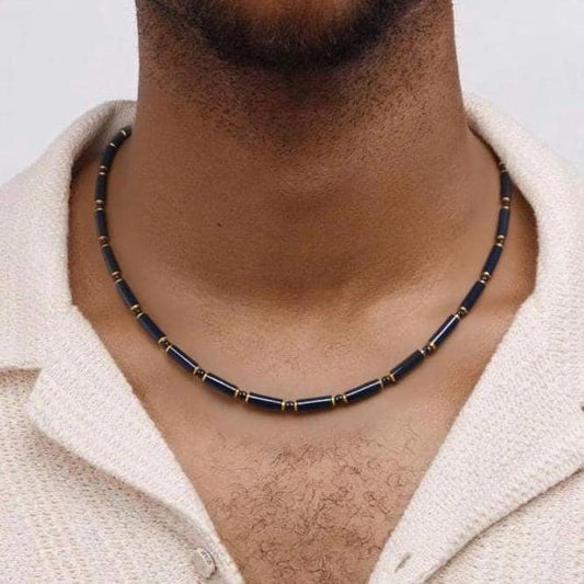 Necklace with black and gold beads worn by a person