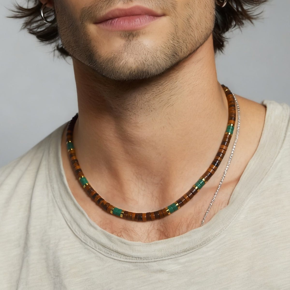 Man wearing tiger's eye and malachite necklace layered over thin silver chain