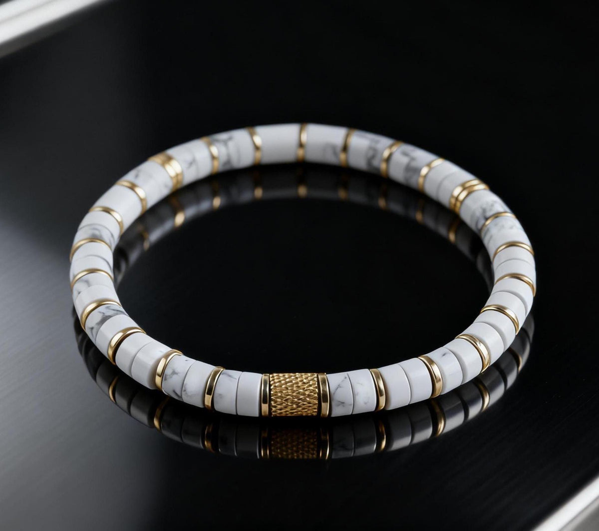 White howlite bracelet with gold spacers on black reflective surface