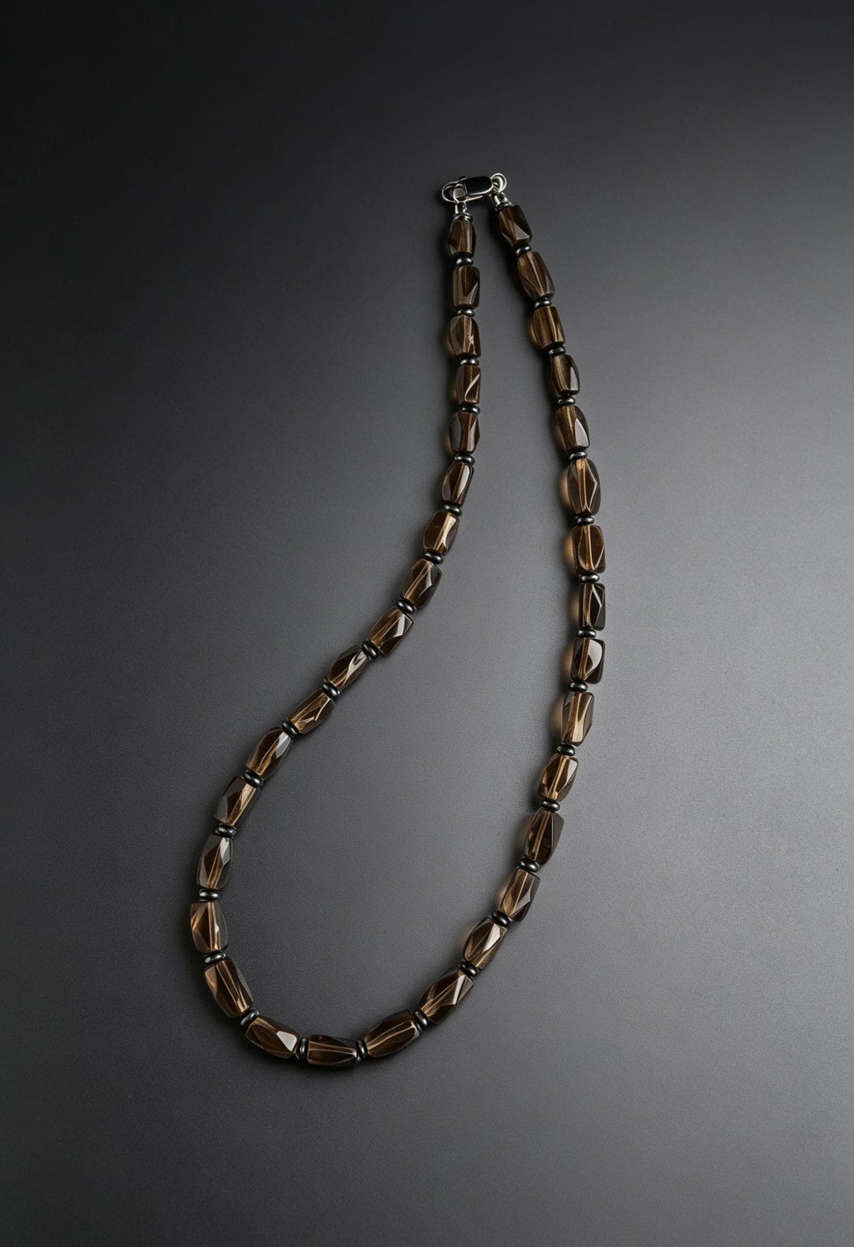 Faceted smoky quartz bead necklace on dark gradient background