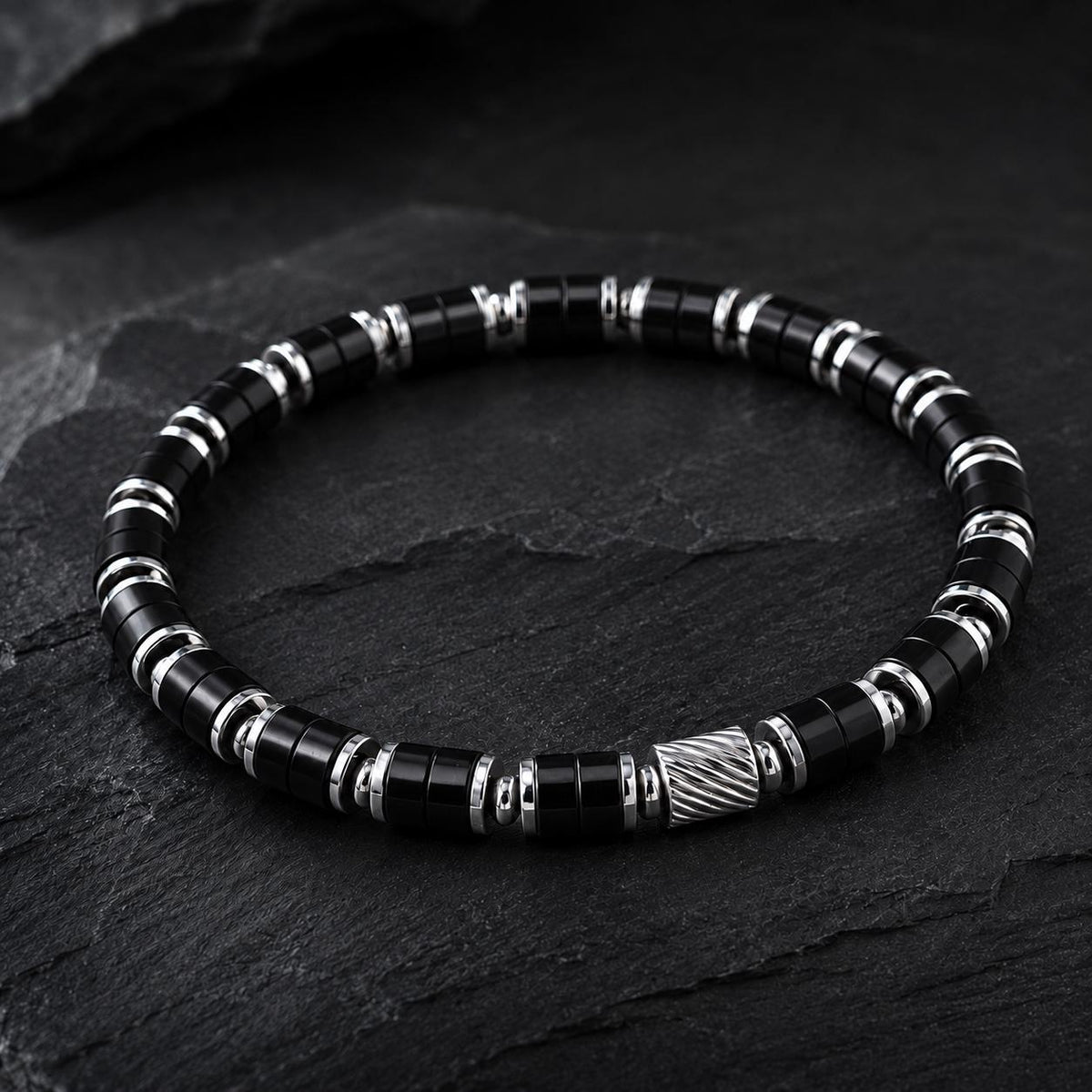 Black onyx beaded bracelet with silver spacers on dark slate
